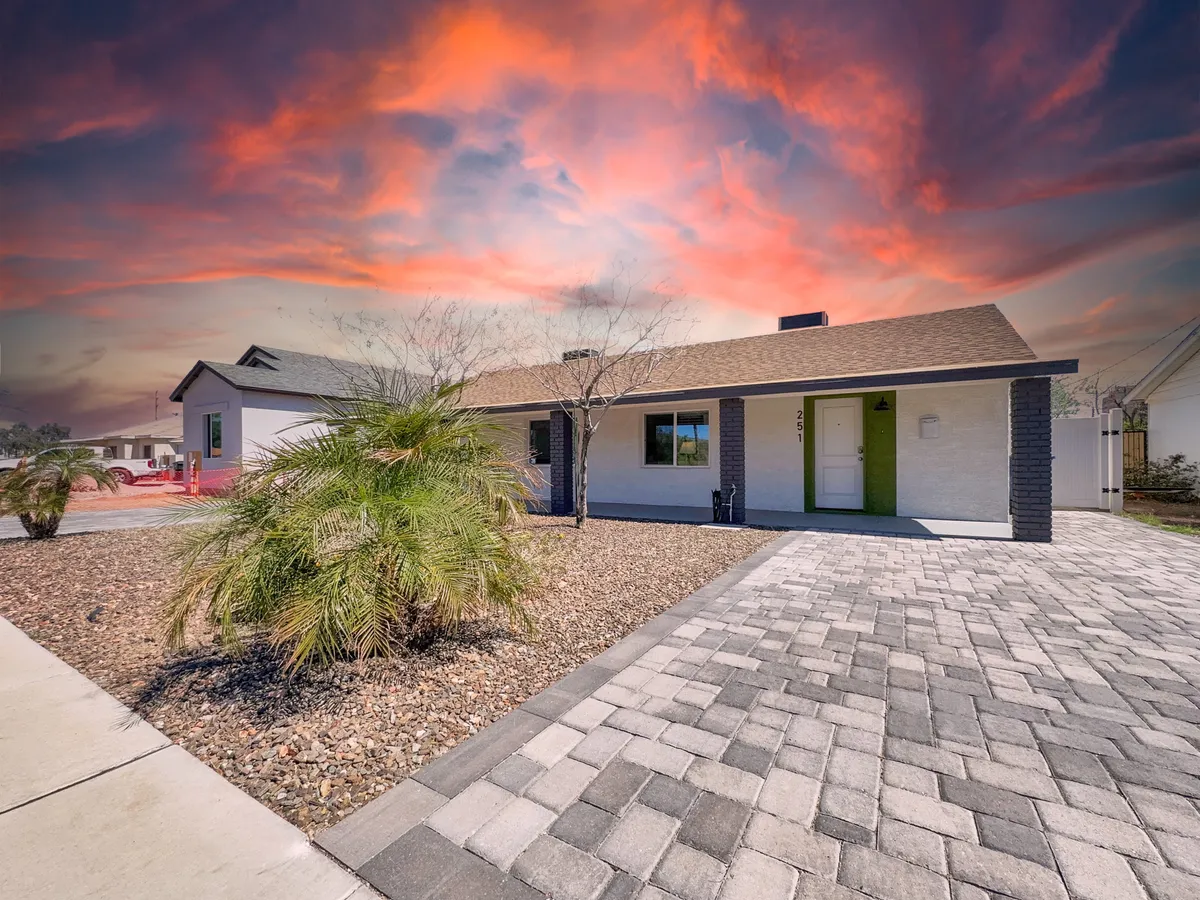 This image captures the house’s facade against a colorful sky, with a landscaped yard in the foreground. The setting sun casts a warm glow over the property, hinting at the tranquility and inviting atmosphere of the neighborhood near Downtown Mesa.